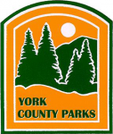 Yellow background with green pine trees in front of a green mountain with a white sun above it. Below the trees, in green text, "York County Parks"