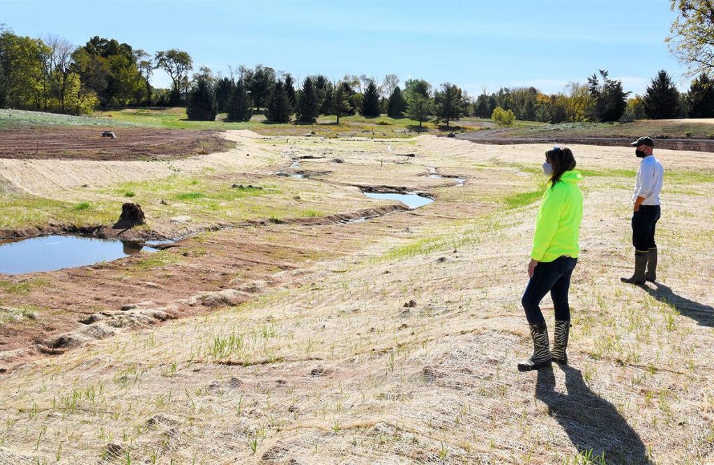 Laurel Oswalt, left, manager of Dover Township, PA, and Reid Garner of LandStudies look at a stream restoration that dug 4 to 6 feet down to recover the original course of two streams and wetlands.